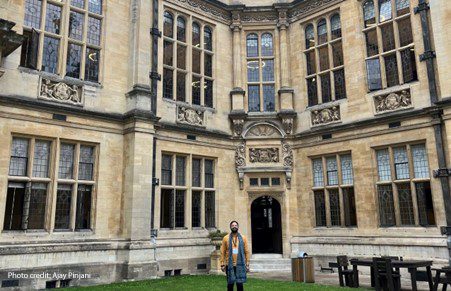 Ajay Pinjani, a 2023 UKFIET conference participant, stands in the quad at the Oxford Exam Schools.