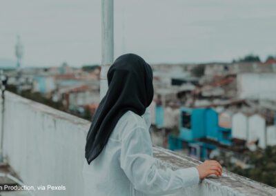 Woman looking at a cityscape from a rooftop.