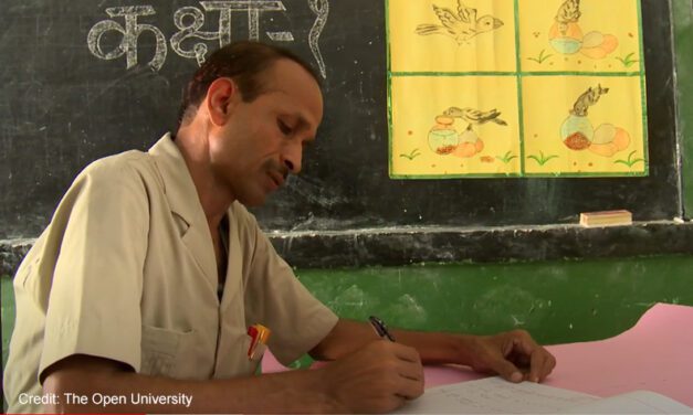 A male teacher writes in a classroom. Taken through the UK-Aid-funded TESS-India project, and a still from a video about TESS-India.