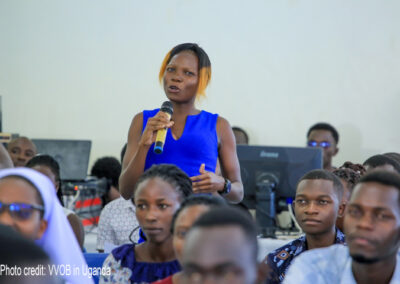Female student-teacher in blue top asks a question during a career talk at Gulu University (September 2023).