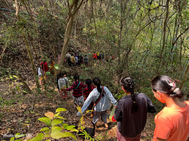 Students returning home through woodland from school from their temporary school site in Karin State, February 2023.