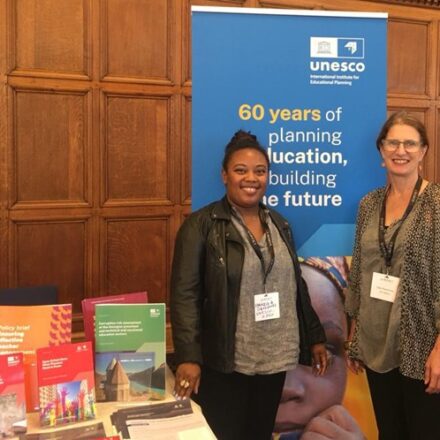 Sally Rosscornes and Fabricia Devignes by a UNESCO 60 years of planning education banner.