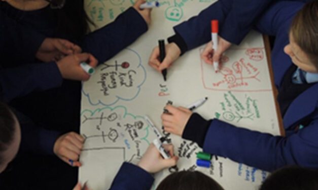 Children's hands adding to a flipchart page using coloured pens at a Creative workshop for Perfect Partner, in a secondary school in Greater Merseyside, 2018.