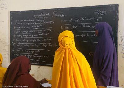 Girls look at the blackboard together in a classroom, Somalia.