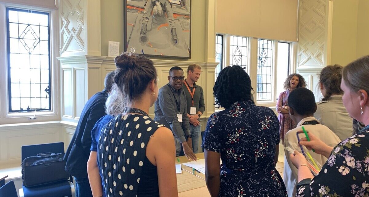 A group gather around a table in a workshop session at the UKFIET Conference 2023