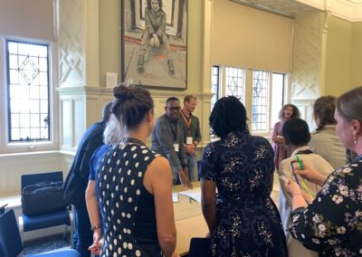 A group gather around a table in a workshop session at the UKFIET Conference 2023