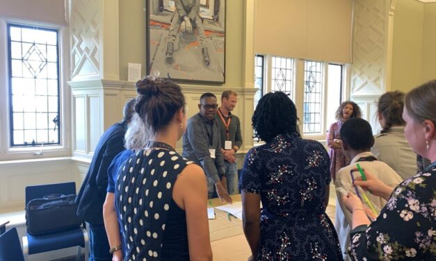 A group gather around a table in a workshop session at the UKFIET Conference 2023