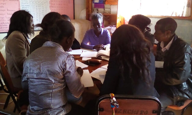 Teachers working together around a table to prepare engaging classroom activities, Zambia.