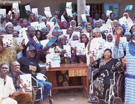 People in Nigeria celebrate the launch of a guide that will help parents of children with disabilities support their child’s education.