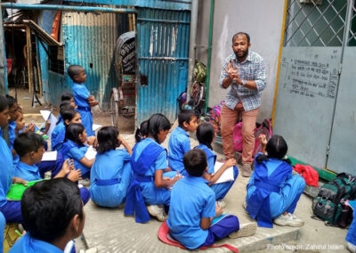 Teacher working with a group of children in blue uniforms