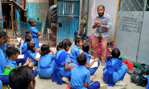 Teacher working with a group of children in blue uniforms