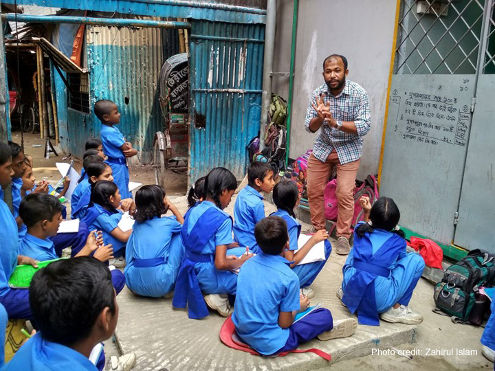 Teacher working with a group of children in blue uniforms