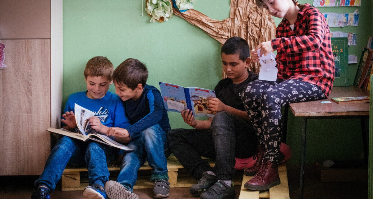 Children look at books together in their primary school class, Bulgaria.