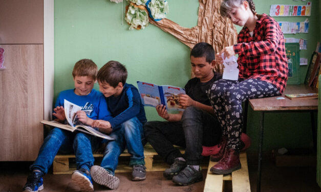 Children look at books together in their primary school class, Bulgaria.