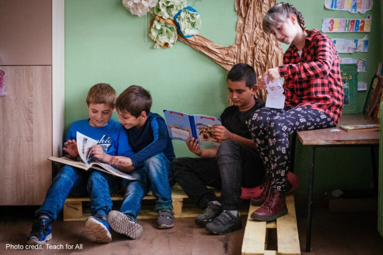 Children look at books together in their primary school class, Bulgaria.