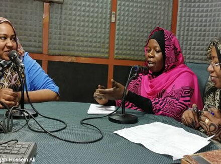 Staff from the university have a discussion in a radio broadcasting room.