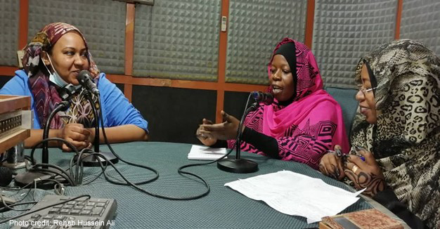 Staff from the university have a discussion in a radio broadcasting room.