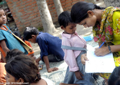 A teacher with children from an informal ‘Bus School’ project which aims to introduce children to formal nearby primary schools when the children are ready.