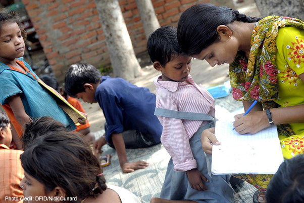 A teacher with children from an informal ‘Bus School’ project which aims to introduce children to formal nearby primary schools when the children are ready.