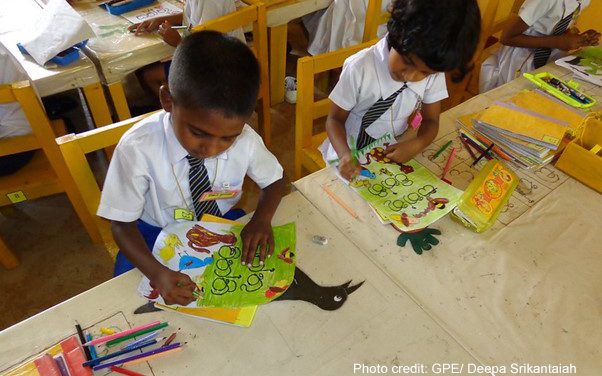 Two primary school children colouring in class, Sri Lanka.