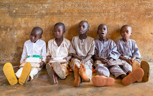 A group of boys sit on the floor leaning against the wall during a lesson at their primary school in Roni, Jigawa State, Nigeria.