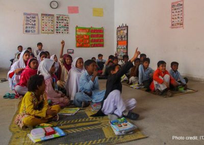 Pre-primary school students sit on mats on the floor of an early childhood education class in Punjab, Pakistan