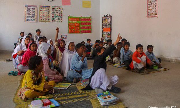 Pre-primary school students sit on mats on the floor of an early childhood education class in Punjab, Pakistan