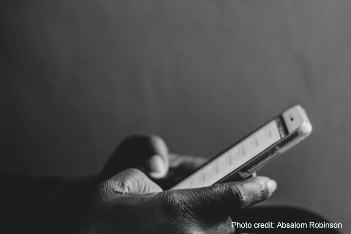 A hand using a mobile phone.