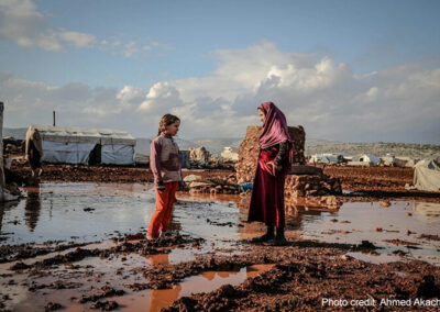 Woman in Hijab Talking with Girl, Idlib, Syria. Area is muddy and flooded
