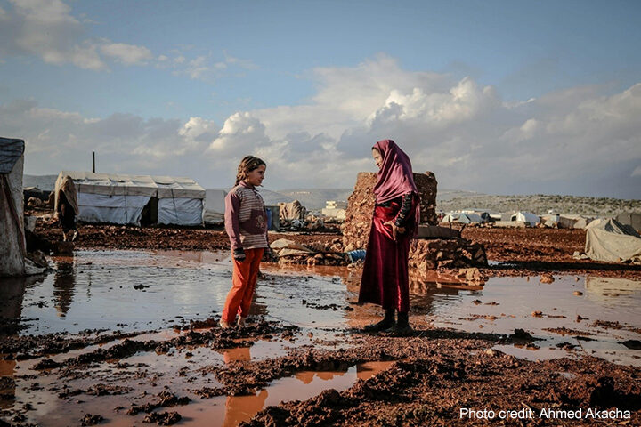 Woman in Hijab Talking with Girl, Idlib, Syria. Area is muddy and flooded