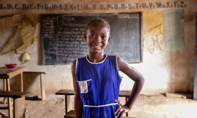 Kadiatu, 12, wearing a blue unform, received monthly cash transfers and follow up support to help her stay in school as part of the Girls In School Initiative, Sierra Leone.