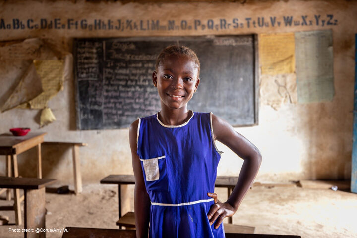 Kadiatu, 12, wearing a blue unform, received monthly cash transfers and follow up support to help her stay in school as part of the Girls In School Initiative, Sierra Leone.