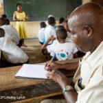 A teacher and students in class at the Nyamachaki Primary School, Nyeri County, Kenya.