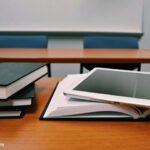 A pile of books and a tablet symbolise learning.
