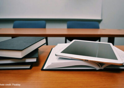 A pile of books and a tablet symbolise learning.