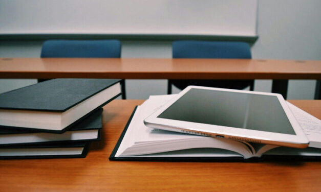 A pile of books and a tablet symbolise learning.