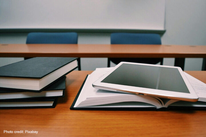 A pile of books and a tablet symbolise learning.