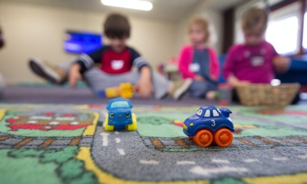 image of children and a toy vehicle on a road play mat