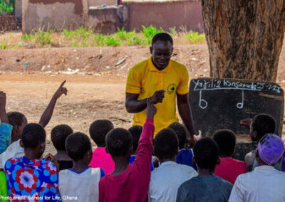 Teacher teaching under a tree in Ghana
