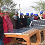 Participants in BRIDGES project with hard hats and solar panels