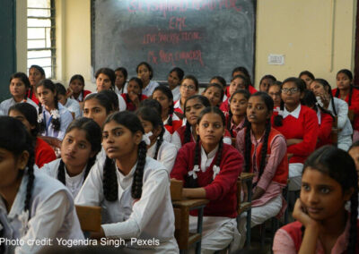 Girls sit in a packed classroom, India.