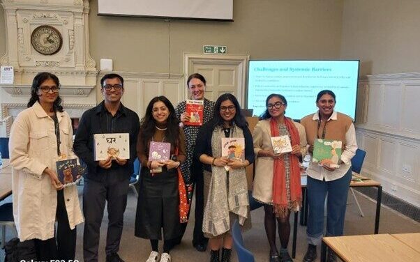 Photp of a group of people in an UKFIET Conference 2025 session holding children's books