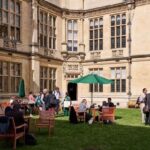 The quad at Examinations Schools, Oxford during the UKFIET Conference with people chatting in the sun