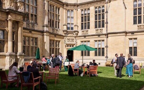 The quad at Examinations Schools, Oxford during the UKFIET Conference with people chatting in the sun