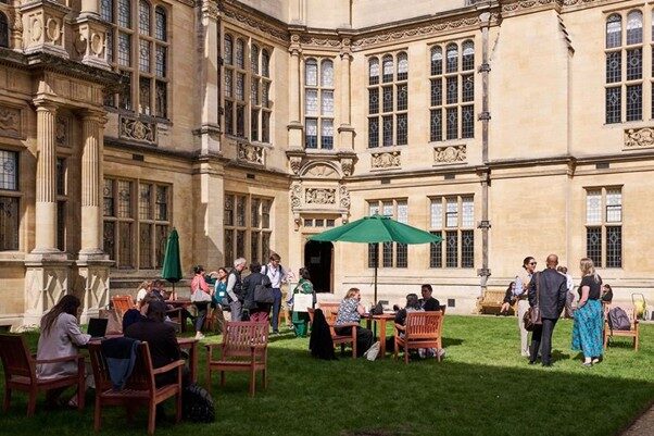 The quad at Examinations Schools, Oxford during the UKFIET Conference with people chatting in the sun