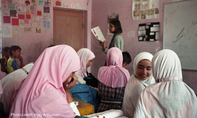 Girls discuss work together in the classroom.