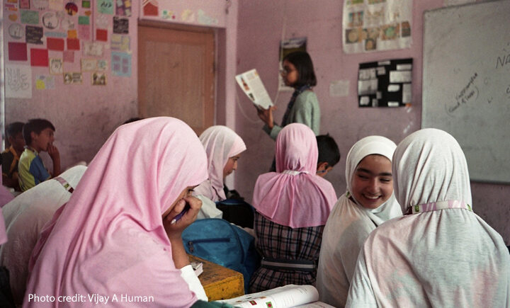 Girls discuss work together in the classroom.