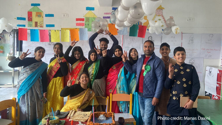 Group of students and teachers celebrate in a classroom.