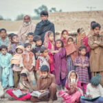 Small group of students outside their rural school with teachers in rural Pakistan.