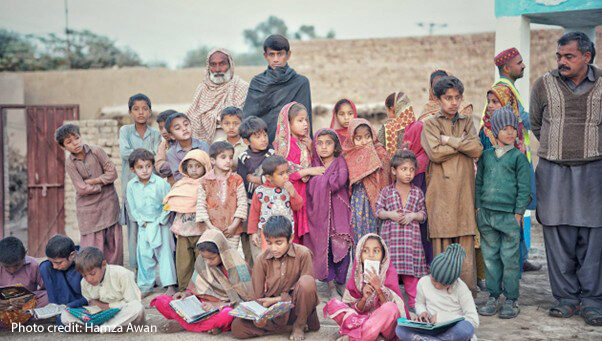 Small group of students outside their rural school with teachers in rural Pakistan.